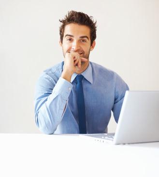 Facility manager souriant devant son ordinateur